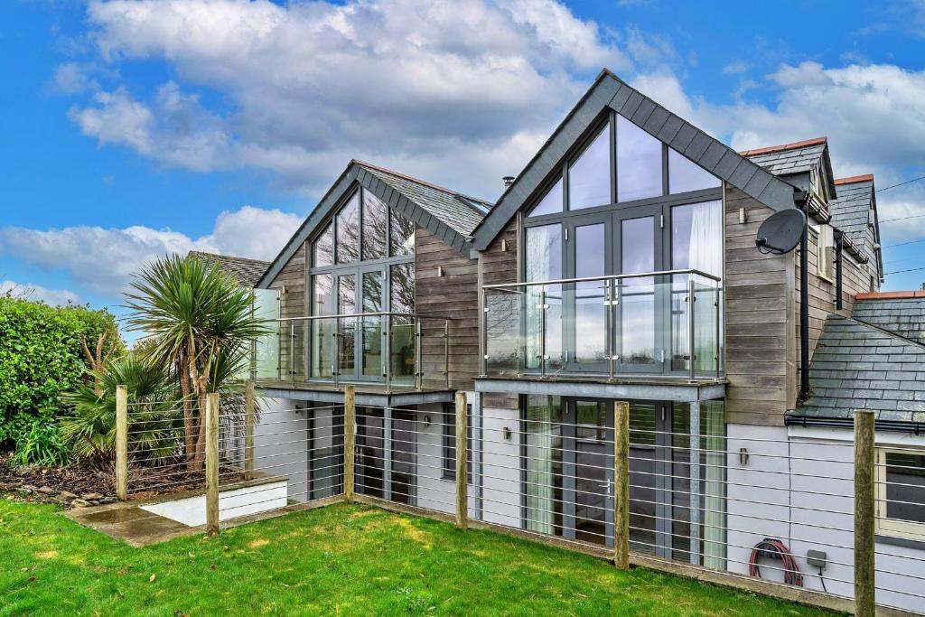 ein Haus mit Glasfenstern und einem Dach in der Unterkunft Finest Retreats - Dingles Cottage in Philleigh