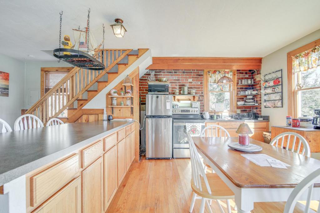 a kitchen with a staircase and a table and chairs at Riverfront Kingston Cottage w/ Deck, 2 Mi to Beach in Kingston