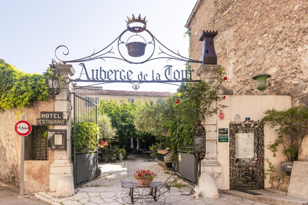 an entrance to an old building with a sign that reads attitude to a court at Auberge de la Tour in Aups