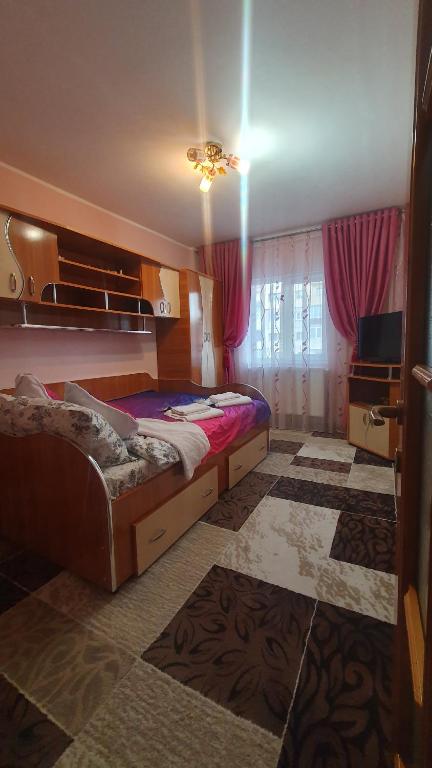 1 dormitorio con 2 camas y TV. en Apartament AKM, en Târgu Ocna