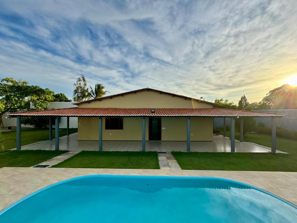een huis met een zwembad ervoor bij Recanto das Margaridas in Pindoretama