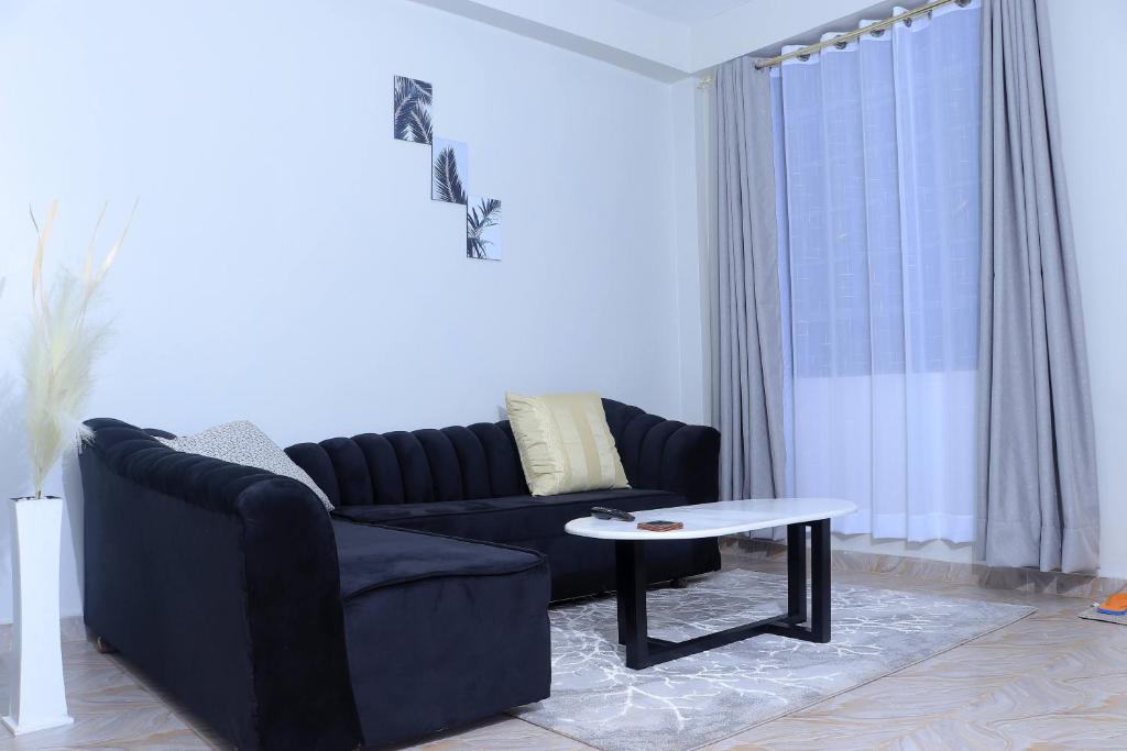 - un salon avec un canapé et une table basse dans l'établissement 1BR Apartment, Canopy apartments Meru near KeMU university Main Campus, à Meru
