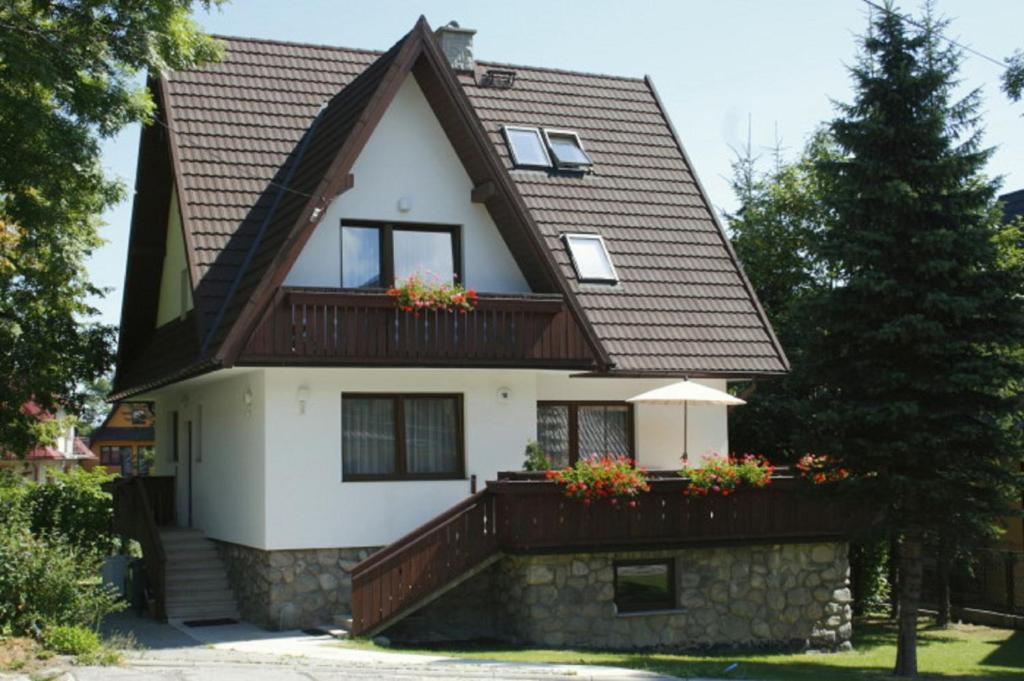 ein weißes Haus mit braunem Dach in der Unterkunft Domek w Górach II in Zakopane