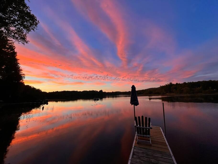 a person sitting on a dock on a lake at sunset at Nala's Lake House Retreat 