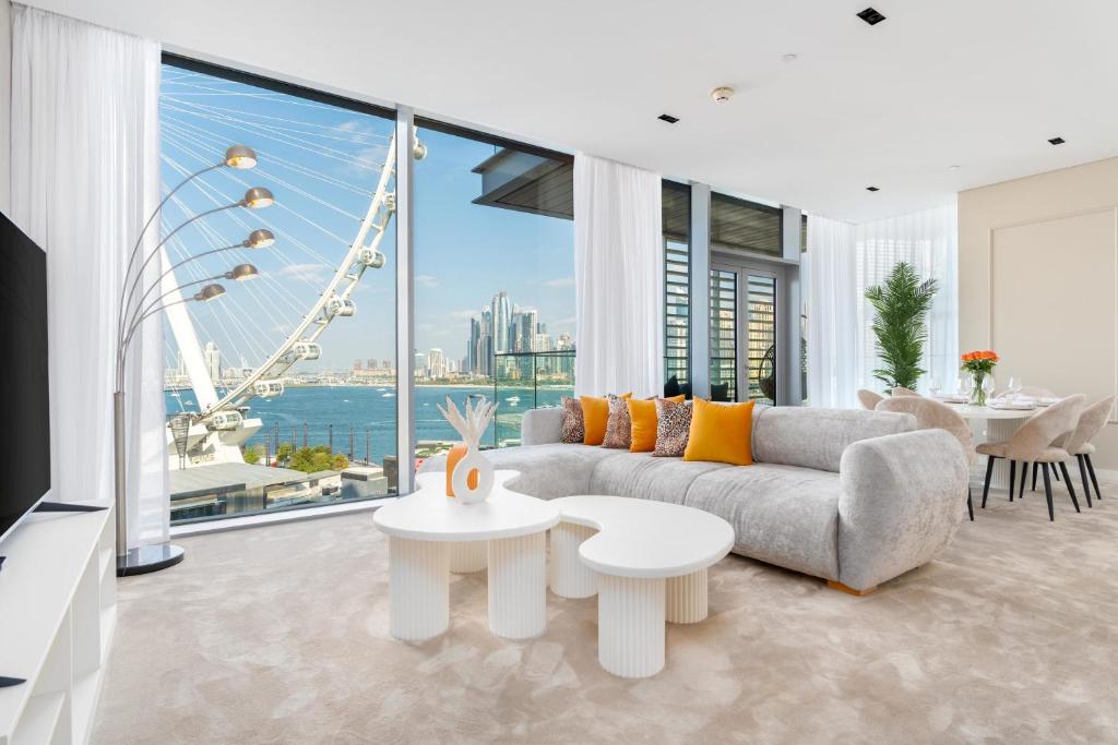 un soggiorno con divano e una grande finestra di Bluewaters Luxe 3BR with maids room - Panoramic Sea View - CityApartmentStay a Dubai