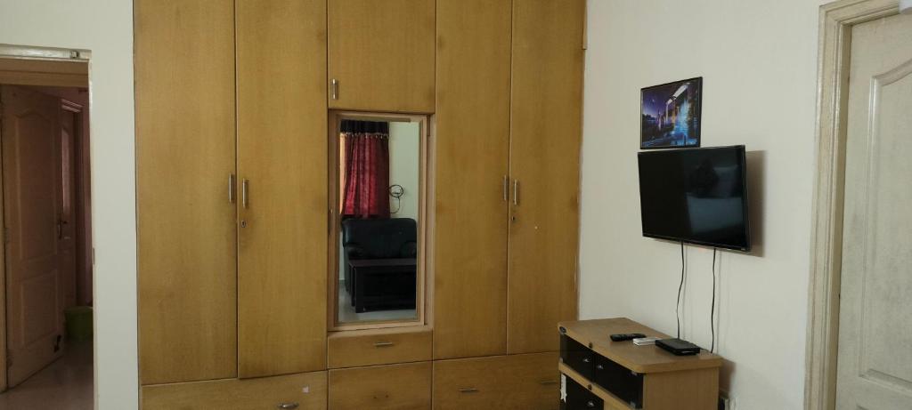 a living room with a tv and a cabinet at Service Apartment Near Rameshwaram Cafe Brookefield in Bangalore