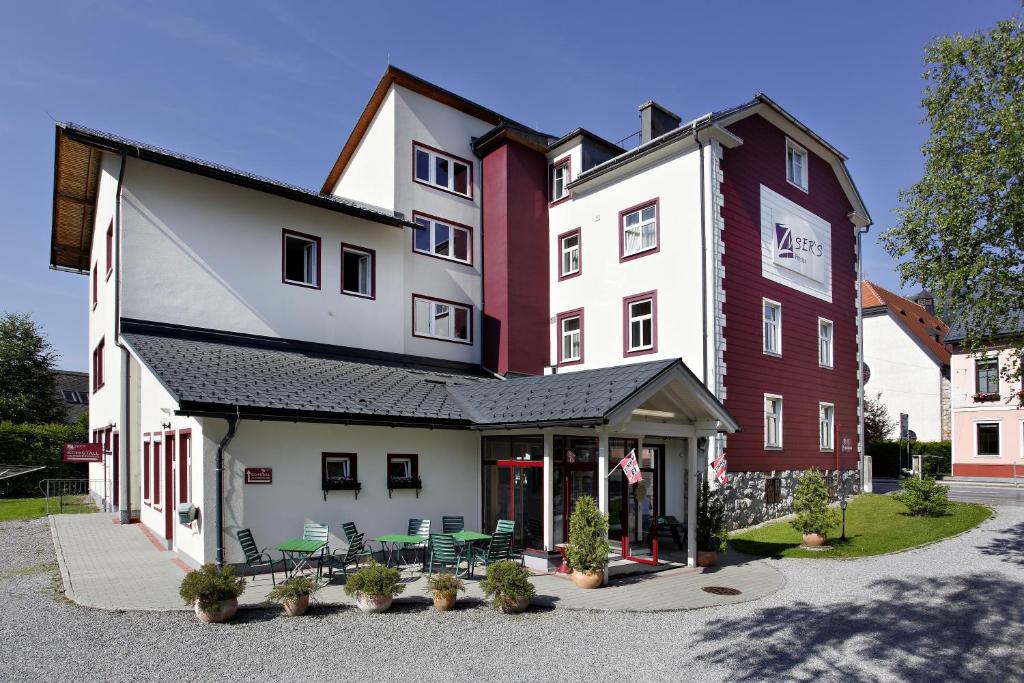 a building with chairs and tables in front of it at Pension Zuser in Mitterbach