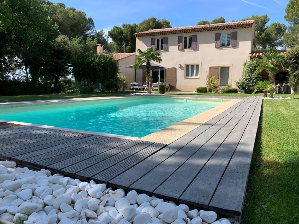 una piscina con terraza de madera junto a una casa en Au Coeur de la Provence, en Éguilles