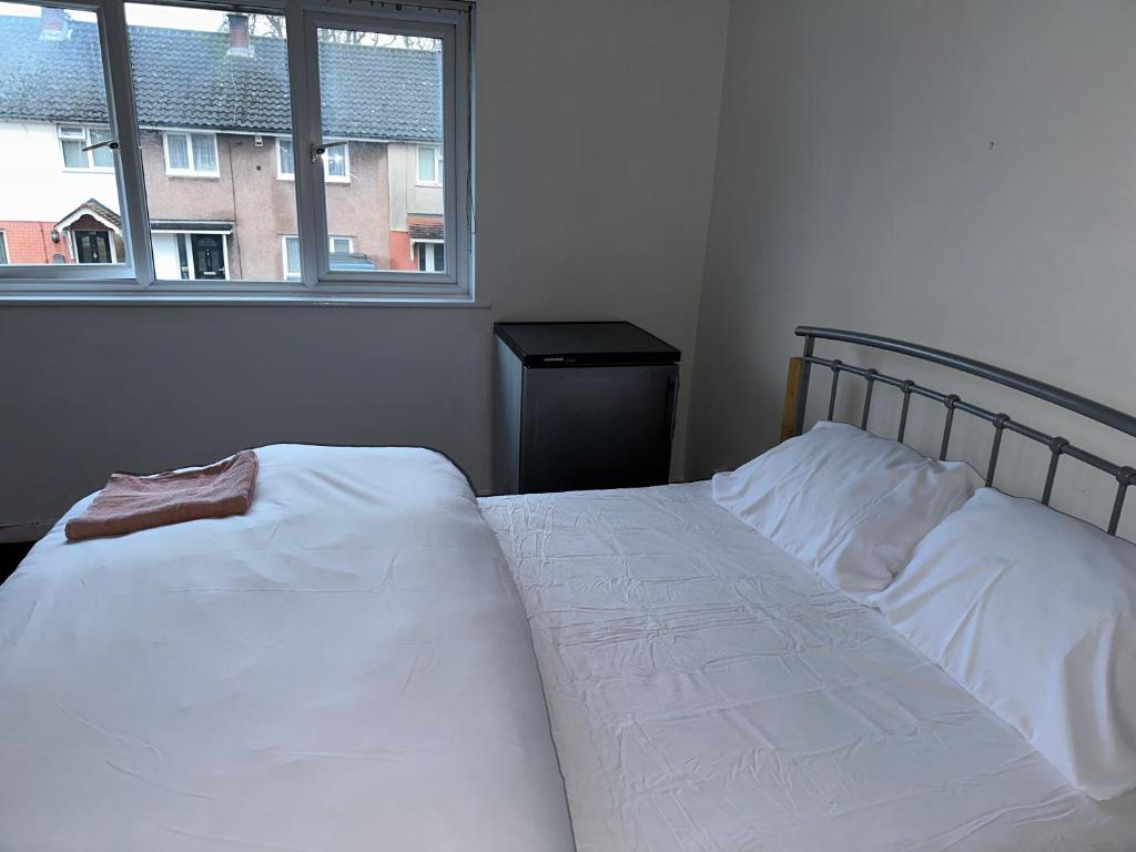 una camera con due letti bianchi e una finestra di Patchway Homestay a Bristol
