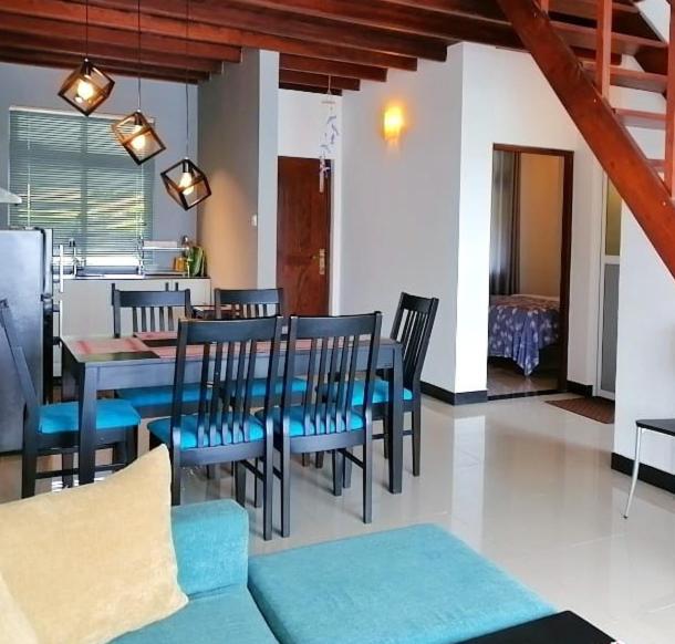 a dining room with a blue table and chairs at Lakeville Residence in Nuwara Eliya
