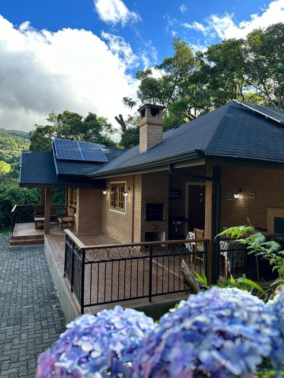 a house with solar panels on the roof at Encanto Chalé in Monte Verde