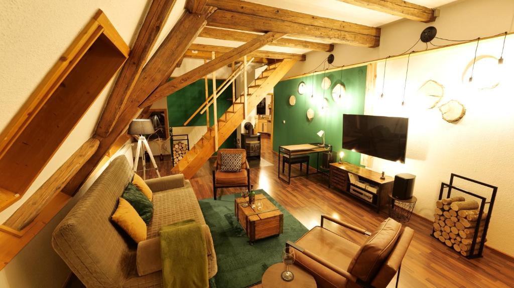 a living room with a couch and a tv at Green Loft Schwarzwald - 120qm - Dach-Balkon in Winzeln