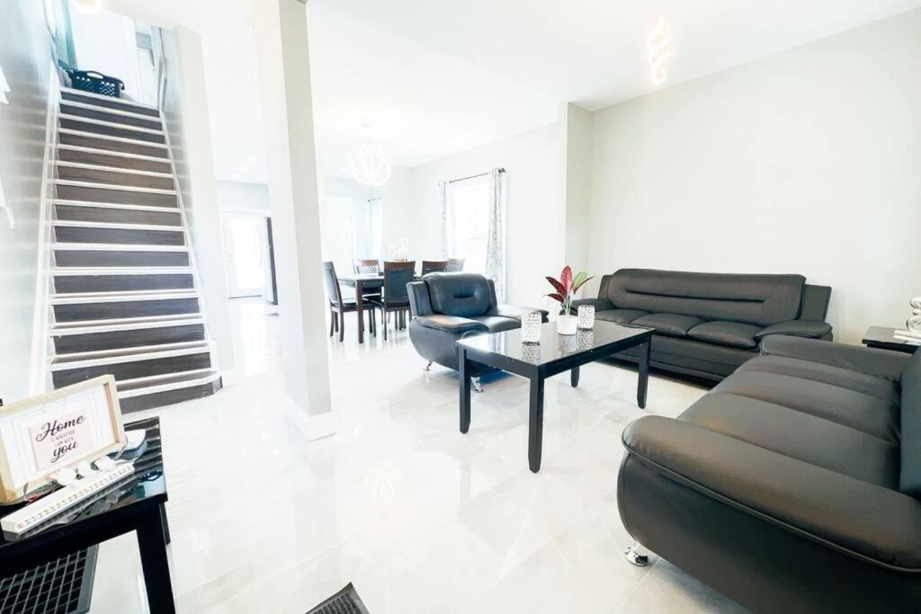 uma sala de estar com um sofá e uma mesa em The Ashland Manor 4BR em Niagara Falls