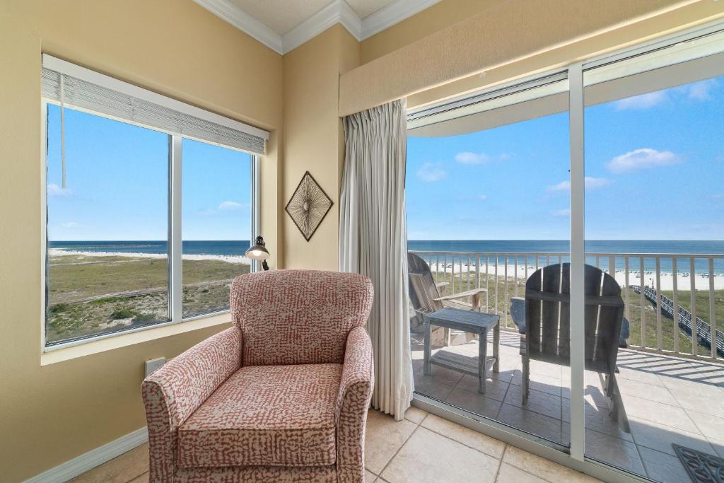 - un salon avec une chaise et une vue sur l'océan dans l'établissement Tidewater 401, à Orange Beach