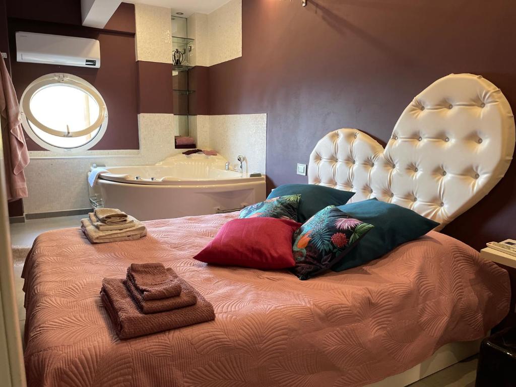 una camera con letto con testiera bianca e vasca di LISCA's Home a Casa del Capitano a Sanremo