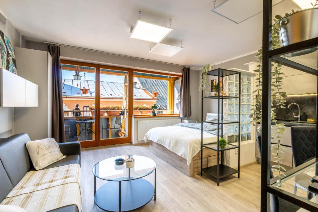 バンスカー・ビストリツァにあるApartmán Strieborná v centre mestaのベッドルーム1室(ベッド1台付)、リビングルームが備わります。