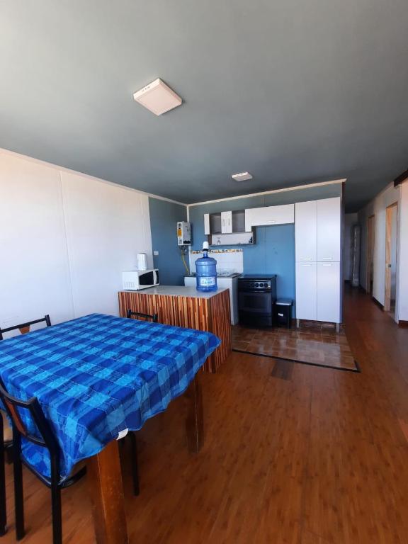 a living room with a table and a kitchen at Cabaña in Pichidangui