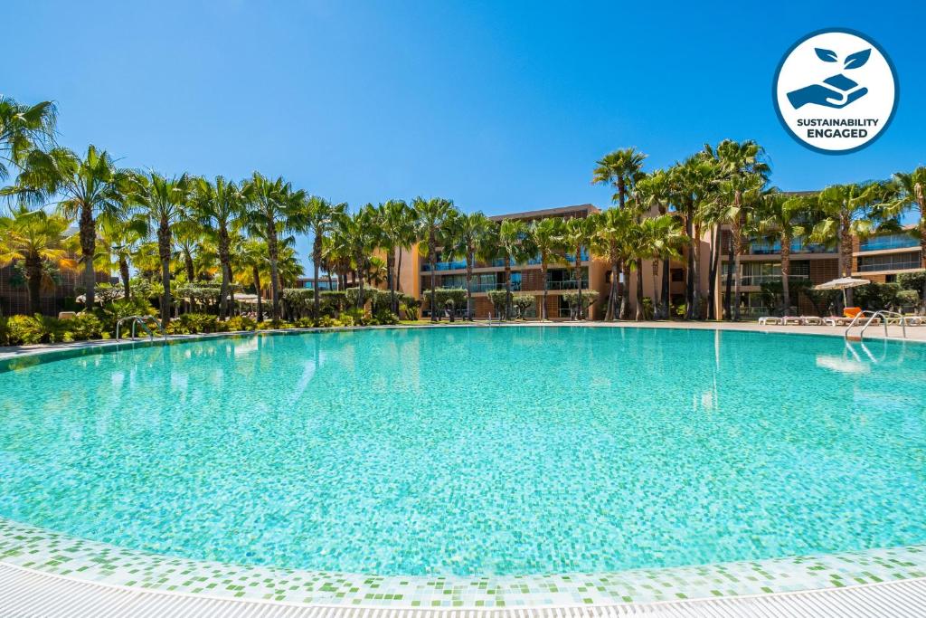 duży basen w ośrodku z palmami w obiekcie Apartment Salgados by Algarve Vacation w Albufeirze