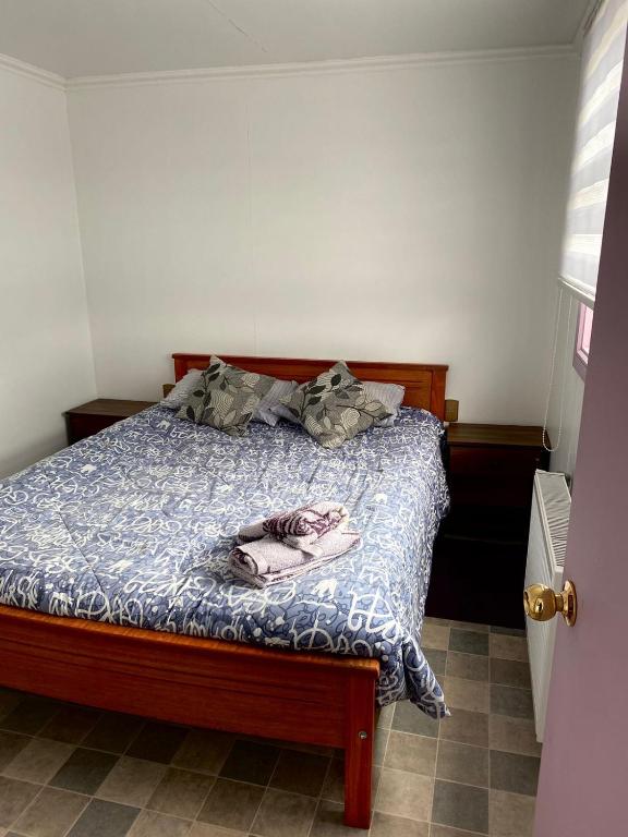 a bedroom with a bed with a blue comforter at Departamentos k&m in Puerto Natales