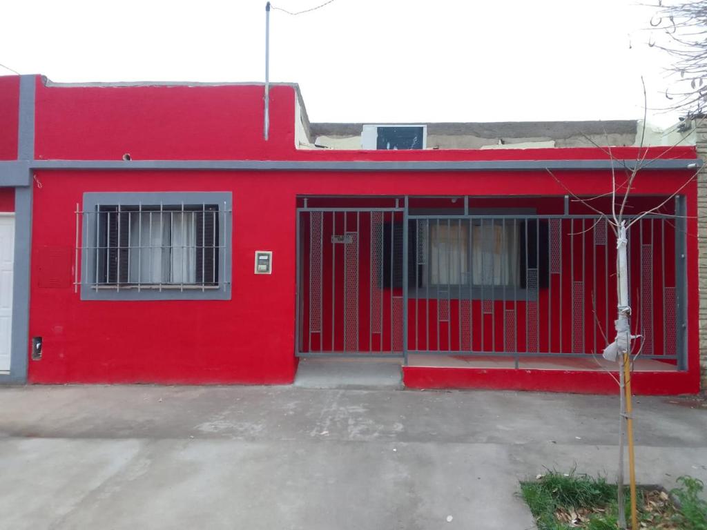 um edifício vermelho com uma porta vermelha e janelas em Casa Grande em Neuquén