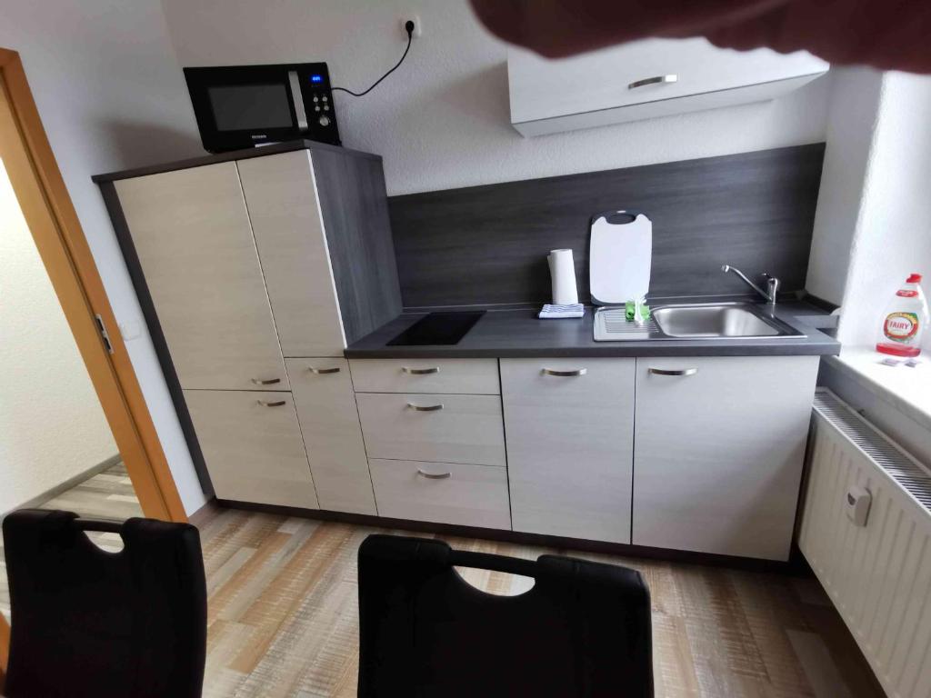 una pequeña cocina con fregadero y microondas en Ferienwohnung Winzer en Annaberg-Buchholz