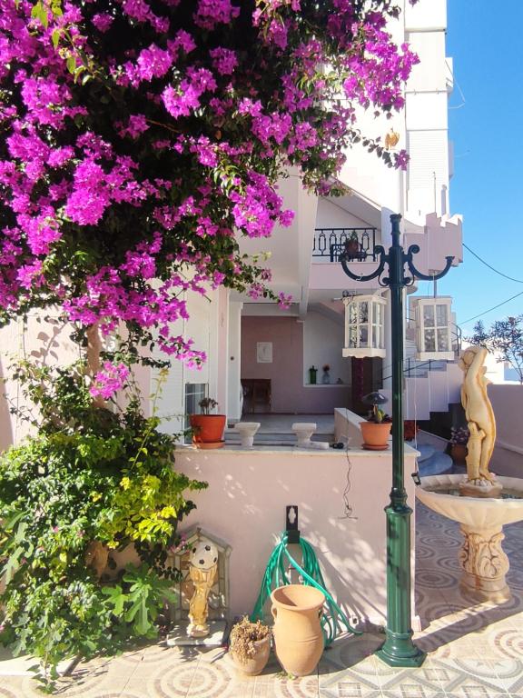 a white building with pink flowers and a street light at Spacious Apartment in Korinthos