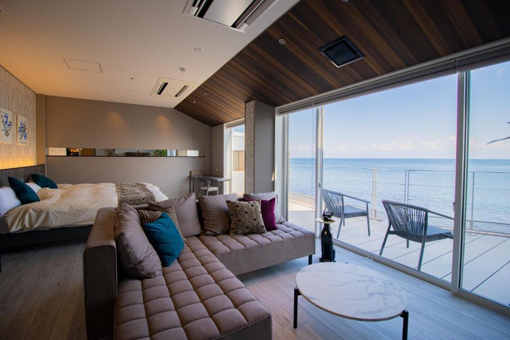 um quarto com um sofá e uma cama com vista para o oceano em La-se-ri Resort & Stay - Vacation STAY 63385v em Himi