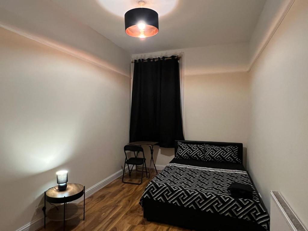 a small bedroom with a bed and a table at 3 Bedroom Apartment in London