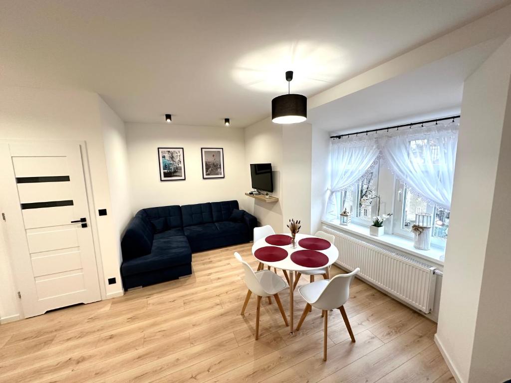 a living room with a table and chairs and a couch at Apartament SASANKA in Kudowa-Zdrój