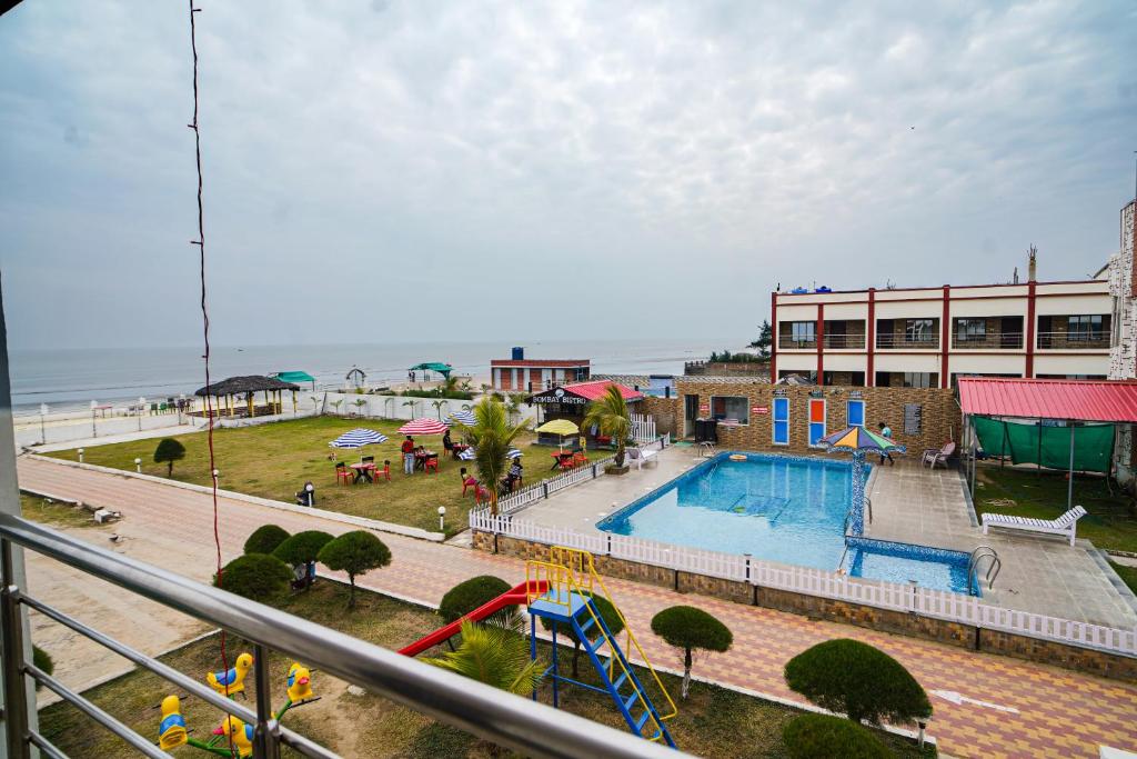 a view of a pool with a playground and a building at Bombay Beach Resort in Mandarmoni