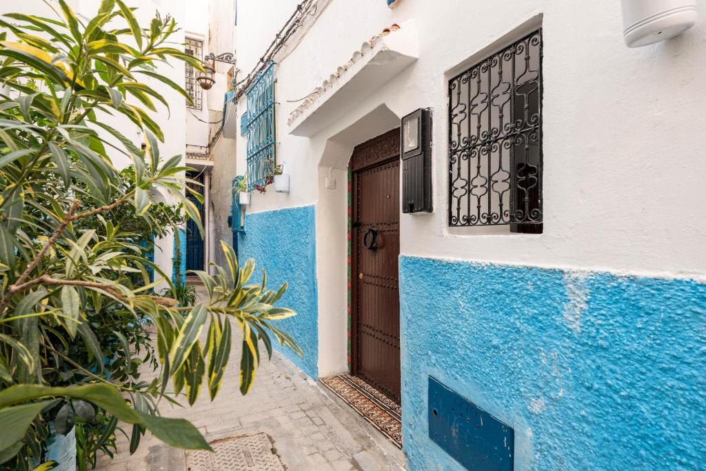 丹吉爾的住宿－Maison Ghazal，一条狭窄的小巷,有蓝色和白色的建筑和门