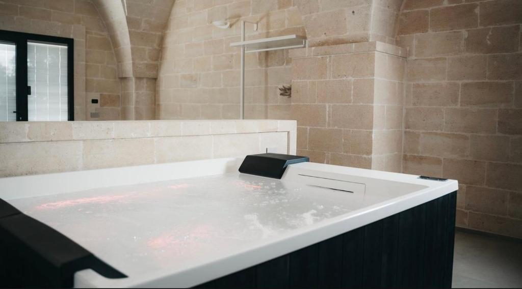 een badkamer met een bad met water erin bij MASSERIA ACQUASALE - RELAIS & RESTAURANT in San Giorgio Ionico