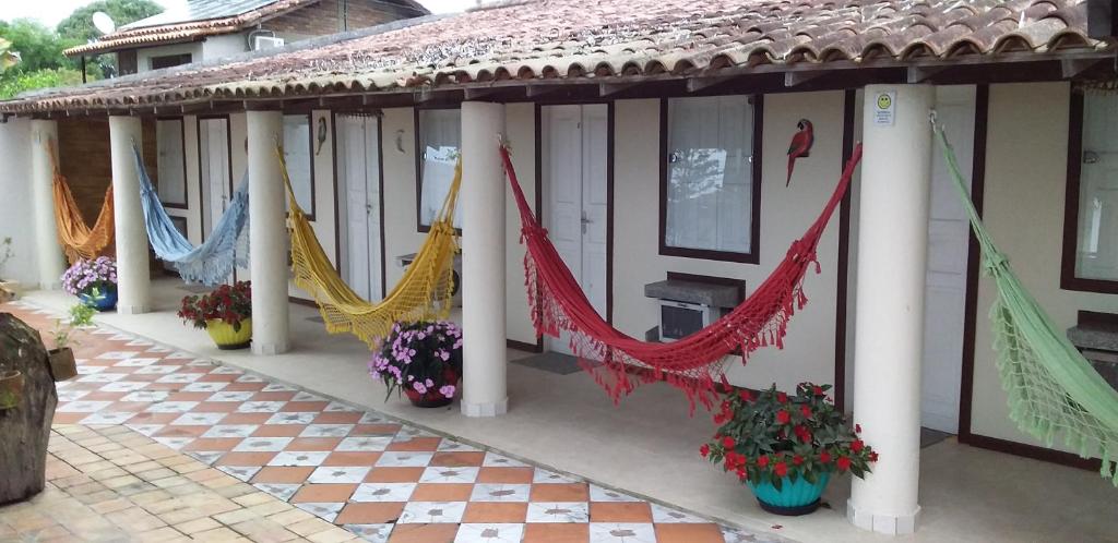 a house with hammocks on the side of it at Pousada Vista Bela in Arraial d'Ajuda
