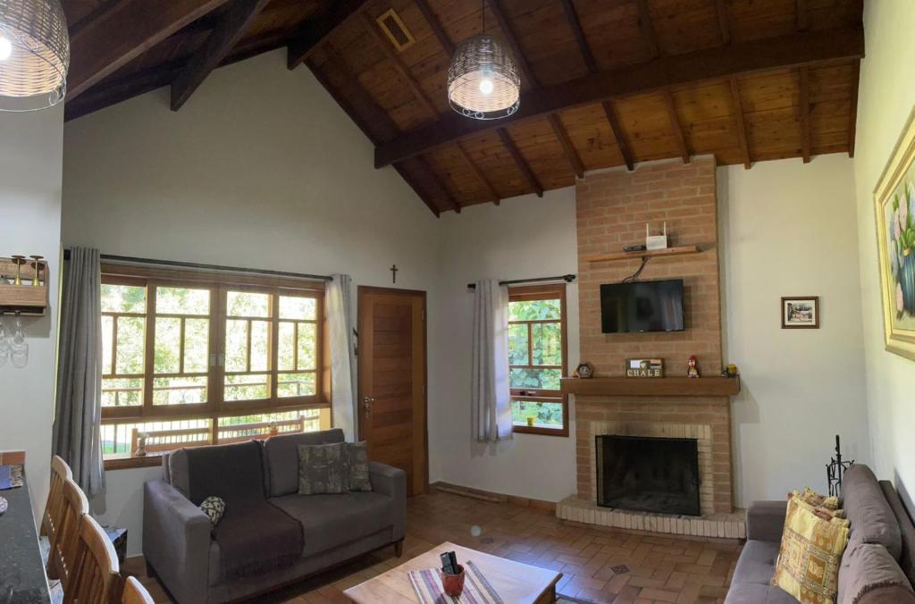 a living room with a couch and a fireplace at Encanto Chalé in Monte Verde
