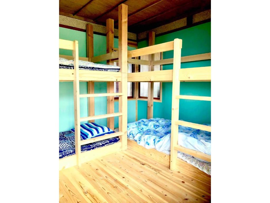 2 Etagenbetten in einem Zimmer mit grünen Wänden in der Unterkunft Obasute Guesthouse Nakaraya - Vacation STAY 31596v in Chikuma