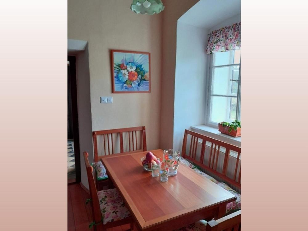 comedor con mesa de madera y ventana en zámek Nemilkov en Velhartice