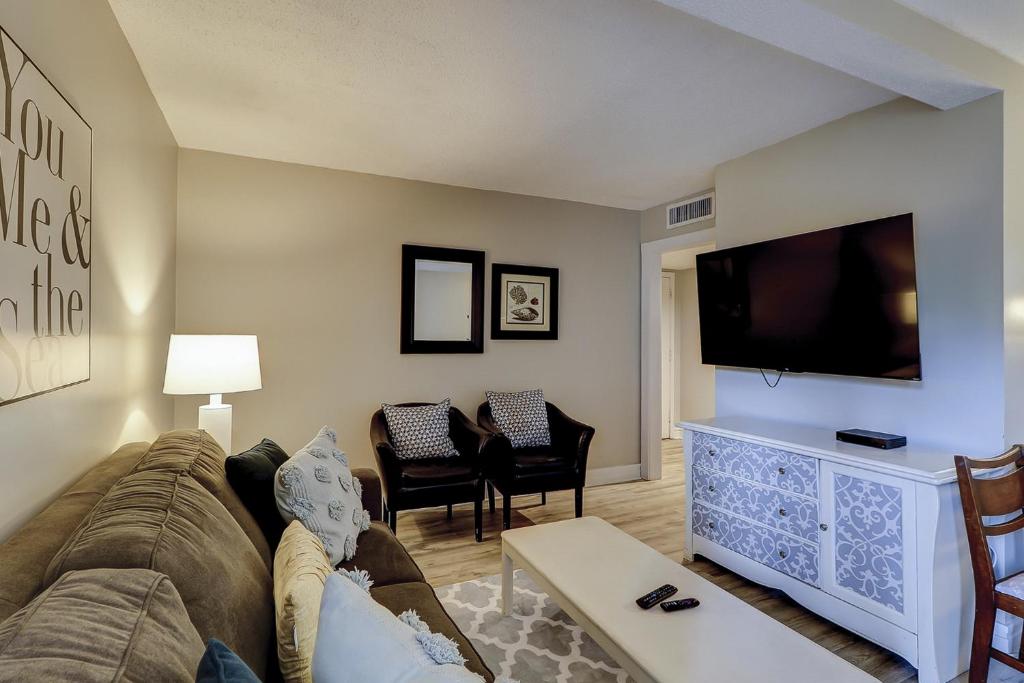 een woonkamer met een bank en een flatscreen-tv bij 8C Xanadu 3 BR Forest Beach in Hilton Head Island