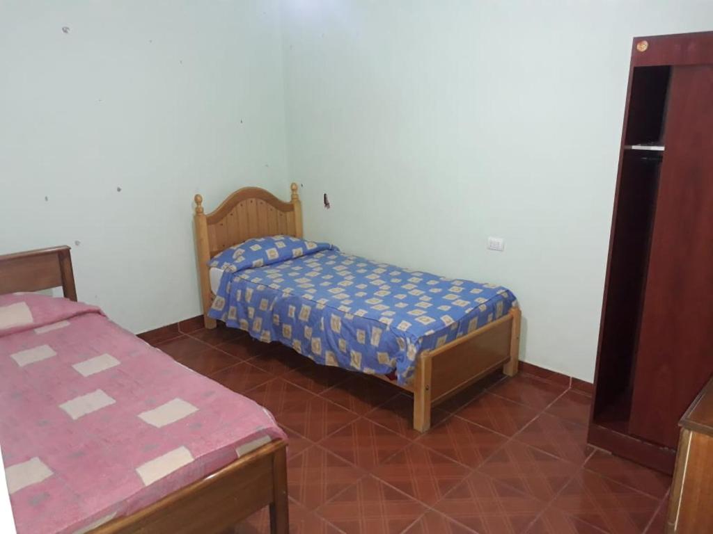 a small bedroom with a bed and a table at Hostal vivar in Calama
