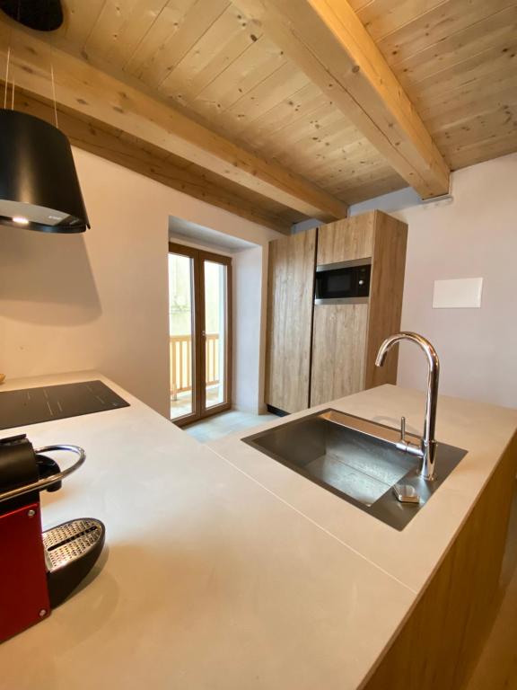 - une cuisine avec un évier et un comptoir dans l'établissement Courmayeur Superior Suite by SupaStays, à Courmayeur