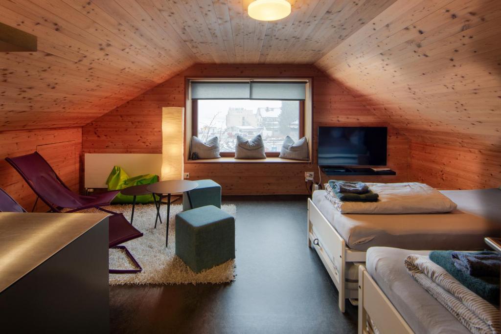 um quarto com uma cama, uma mesa e uma janela em UnderDach em Andermatt