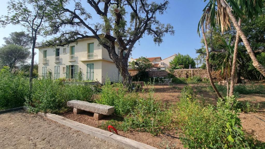 un banc dans un jardin en face d'un bâtiment dans l'établissement Vacances en Famille ou entre Amis, à Saint-Raphaël