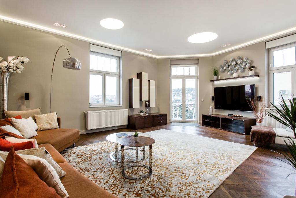 een woonkamer met een bank en een tv bij Luxurious Danubeside Apartment for 6 in Boedapest