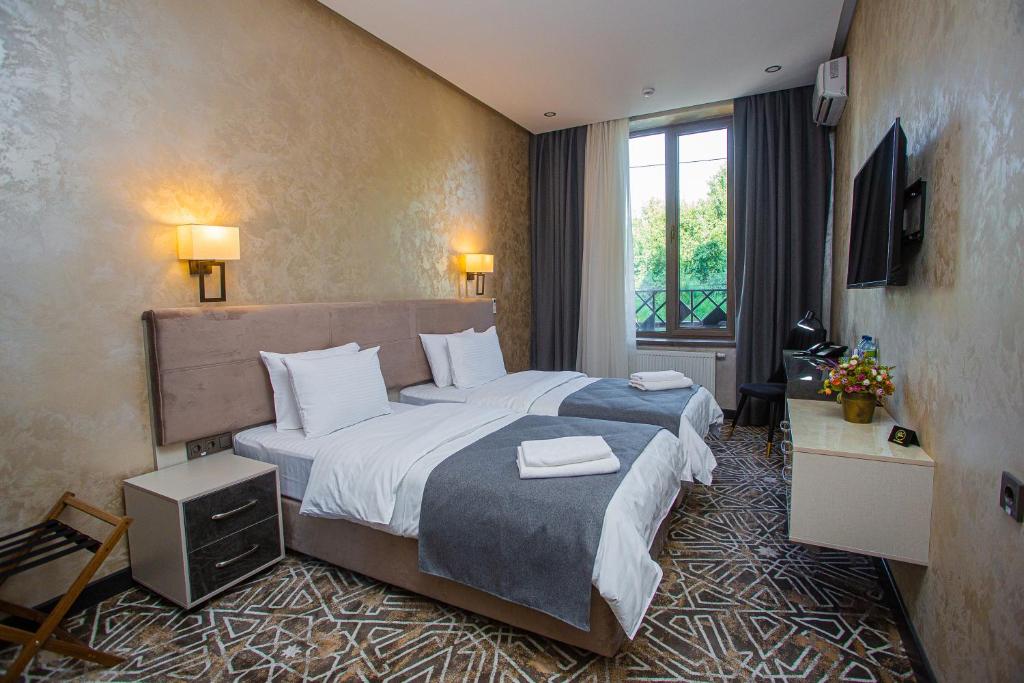 pokój hotelowy z dużym łóżkiem i oknem w obiekcie Florence Boutique Hotel by Hotel Pro group w mieście Yakkasaray