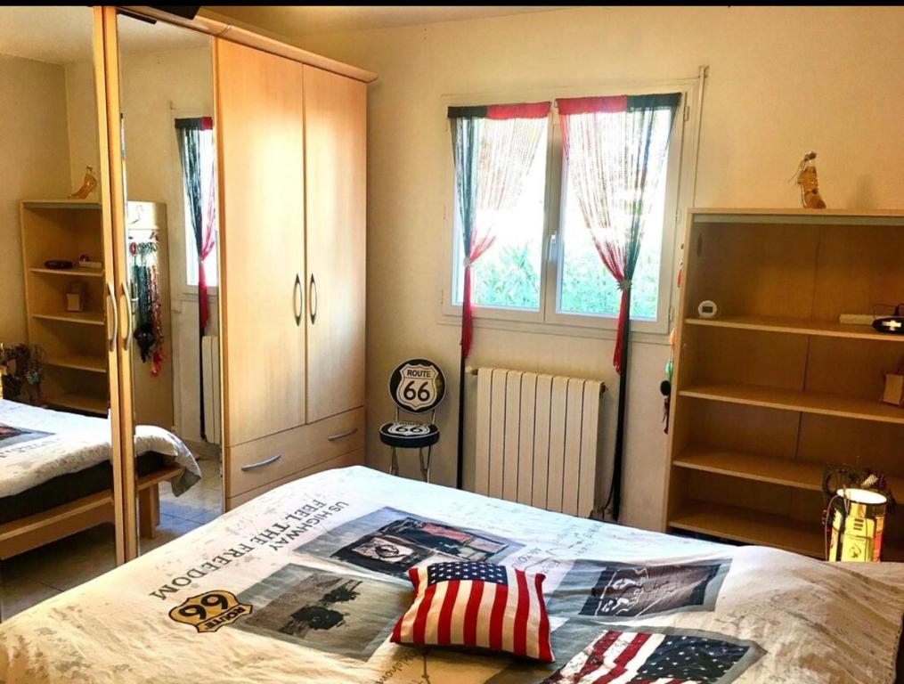 Schlafzimmer mit einem Bett mit amerikanischer Flagge in der Unterkunft Villa Piscine Mer 66 in Saint-Laurent-de-la-Salanque