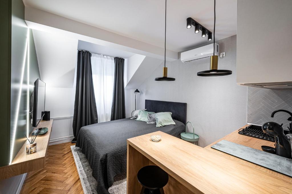 a small bedroom with a bed and a desk at Pistachio apart City center in Novi Sad