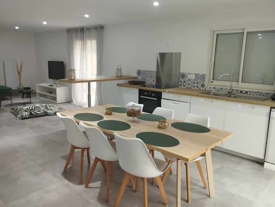 - une cuisine avec une table en bois et des chaises blanches dans l'établissement Maison 115 m 2 avec Jardin, à Carignan