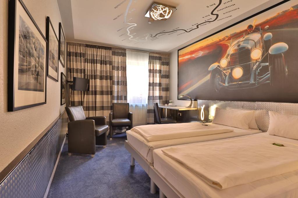 バート・メルゲントハイムにあるApart Hotel Deutschmeisterのベッド2台が備わる客室で、壁には絵画が飾られています。