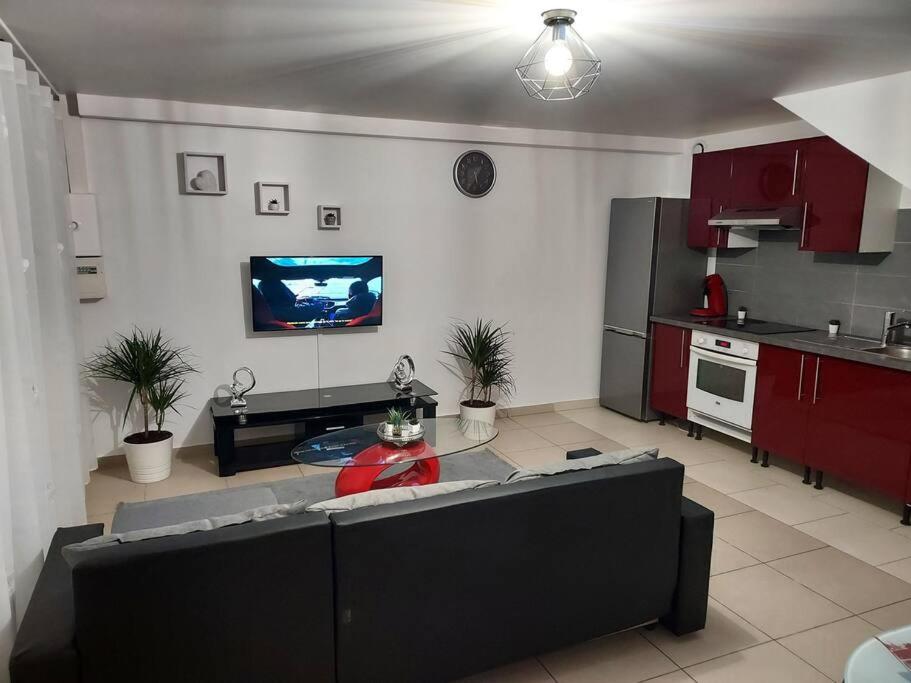 ein Wohnzimmer mit einem Sofa und einem TV an der Wand in der Unterkunft Appartement en duplex A113 in Draveil