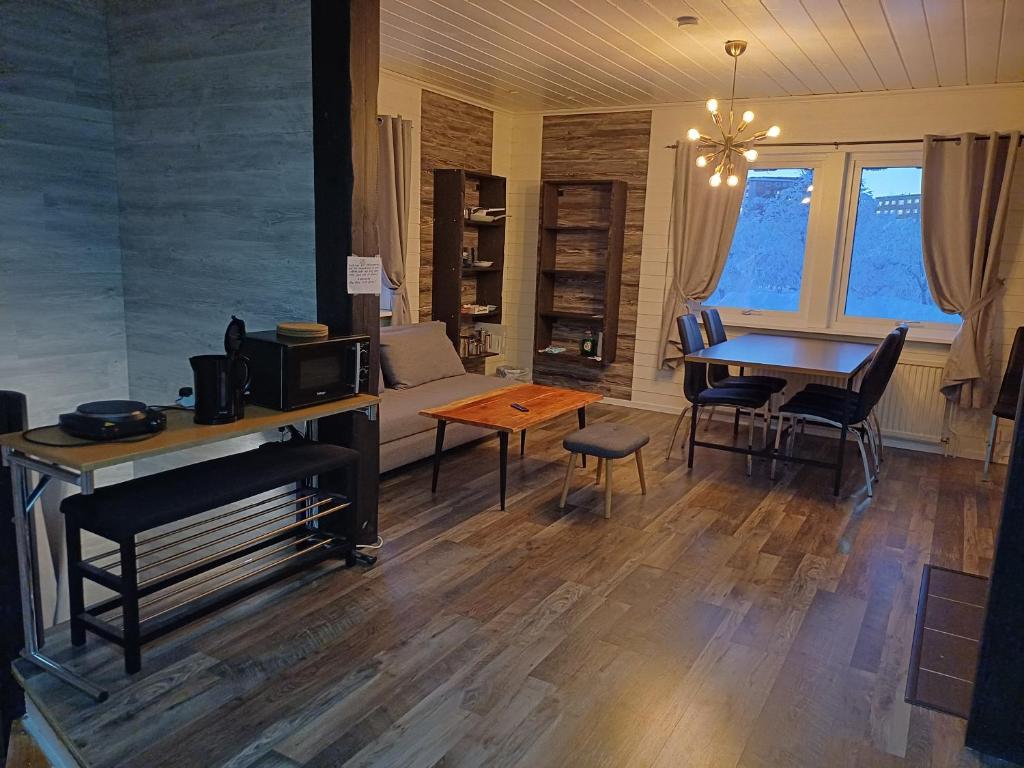 Kiruna accommadation Sandstensgatan 24 في كيرونا: غرفة معيشة مع طاولة وأريكة