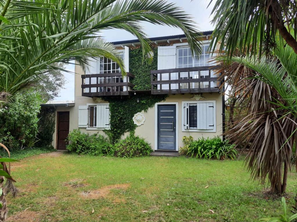 een huis met een palmboom ervoor bij ROMFER II in San Eduardo del Mar